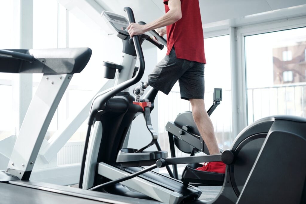 Person performing high-intensity interval training on an elliptical machine